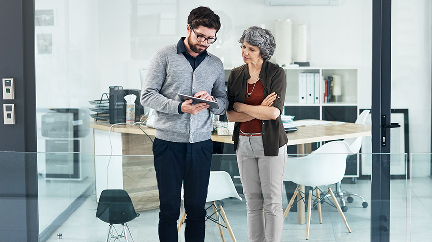 A middle aged lady is discussing investment plan with a man in office; image used for HSBC India Mutual Funds page